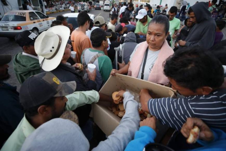 Voluntarios locales regalaron café con pan dulce a los cientos de migrantes que se aprestaban a iniciar su caminata hacia la ciudad de Huixtla, donde acamparán esta noche para retomar mañana su camino hacia la frontera entre Tamaulipas y California.