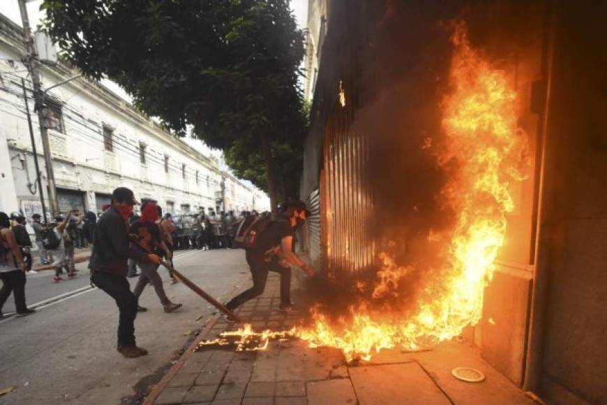 Demonstrators set on fire part of the Congress building during a protest demanding the resignation of Guatemalan President Alejandro Giammattei, in Guatemala City on November 21, 2020. - The Vice President of Guatemala, Guillermo Castillo, asked President Alejandro Giammattei to resign together for 'the good of the country,' after the 2021 budget -the largest in history, which generates indebtedness and rejection among Guatemalans- was approved in Congress. (Photo by Orlando ESTRADA / AFP)