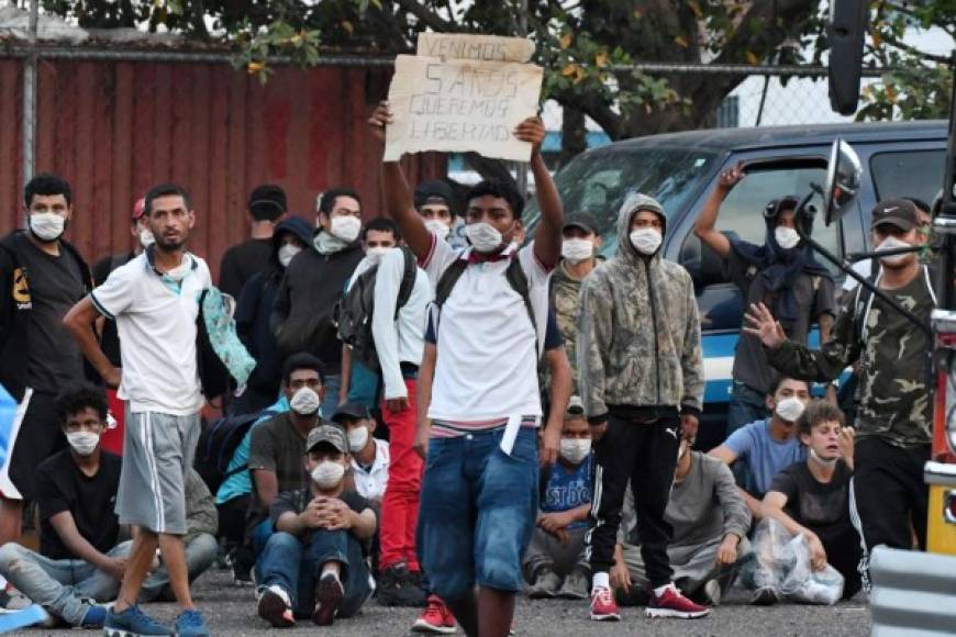 Migrantes hondureños deportados de México hacen cola para subirse a un autobús luego de ser notificados que serían puestos en cuarentena. AFP