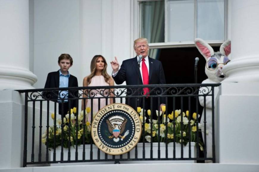 Barron Trump (L) and US First Lady Melania Trump (2L) listen as US President Donald Trump (2R) speaks during the Easter Egg Roll on the South Lawn of the White House April 17, 2017 in Washington, DC. / AFP PHOTO / Brendan Smialowski