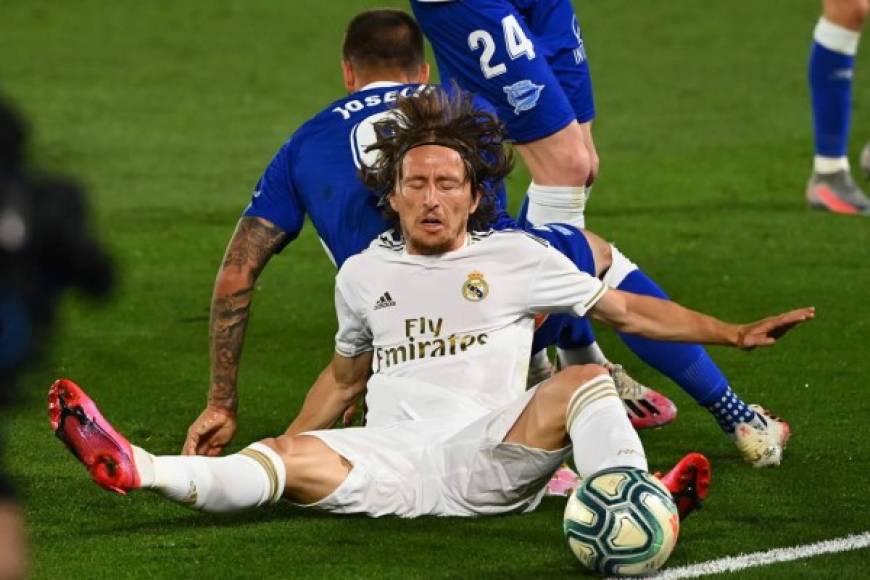 Luka Modric cae al césped tras disputar el balón con Joselu.