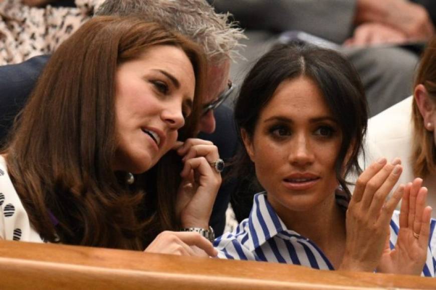 Britain's Catherine, Duchess of Cambridge, (L) and Britain's Meghan, Duchess of Sussex react as they sit in the Royal box on Centre Court to watch Serbia's Novak Djokovic play against Spain's Rafael Nadal during the continuation of their men's singles semi-final match on the twelfth day of the 2018 Wimbledon Championships at The All England Lawn Tennis Club in Wimbledon, southwest London, on July 14, 2018. / AFP PHOTO / Oli SCARFF / RESTRICTED TO EDITORIAL USE