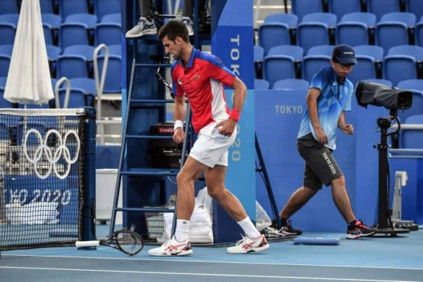 Djokovic destronó una de sus raquetas. Al fondo, uno de los ayudantes para pasar las pelotas se asustó con la furia del serbio.