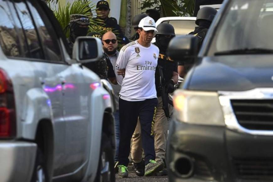 Honduras' police chief of human resources Leonel Sauceda, is escorted by police after being arrested in Tegucigalpa on February 11, 2020. - Senior Honduran police officer Leonel Sauceda, was arrested on Tuesday with his wife, accused of money-laundering, the Criminal Investigation Technical Agency (ATIC) reported. (Photo by ORLANDO SIERRA / AFP)