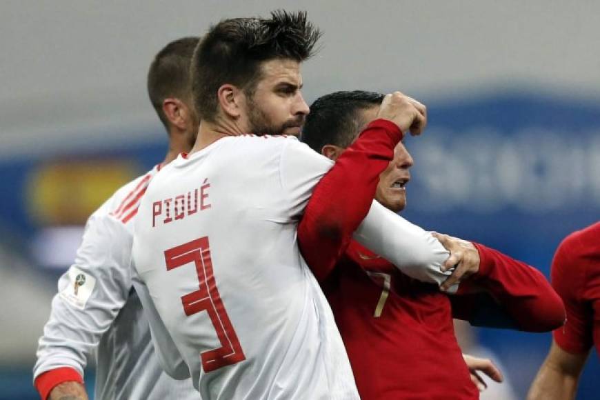 Gerard Piqué sujetó fuerte a Cristiano Ronaldo en la jugada. Foto AFP