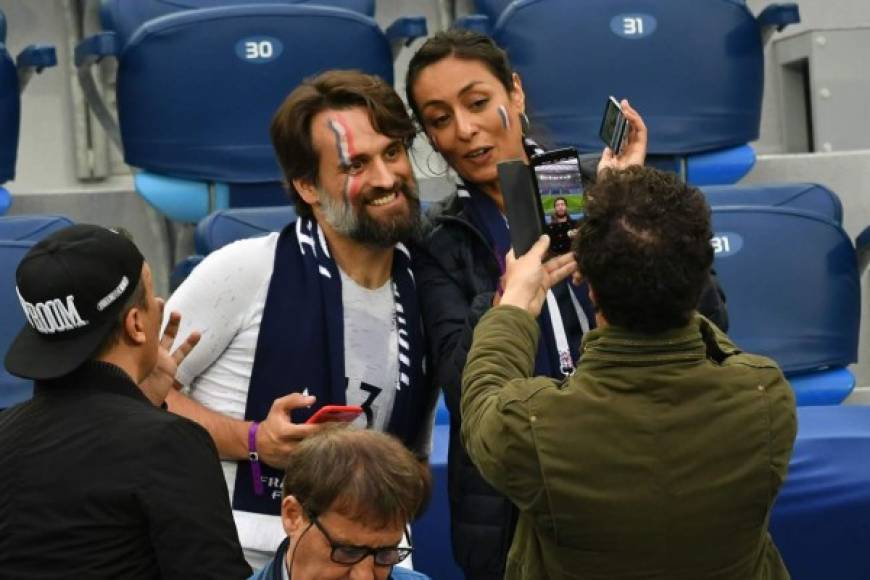 La presentadora de televisión francesa Leila Kaddour-Boudadi posa para una foto con un aficionado francés en las gradas del estadio.