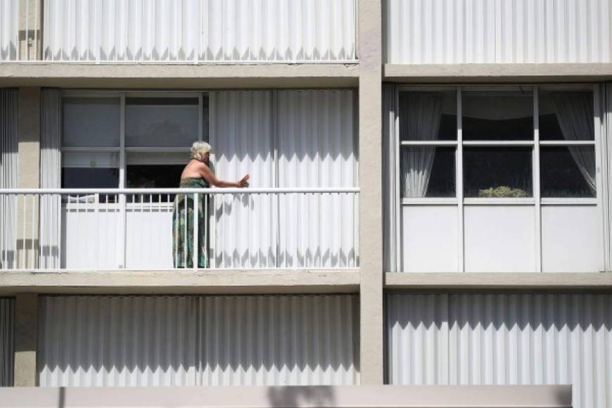 Una mujer trabaja en el cierre de las ventanas en un condominio mientras se prepara para el huracán Irma. AFP