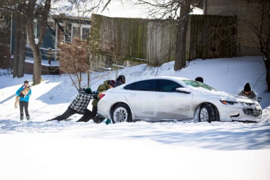 AUSTIN, TX - FEBRUARY 15: East Austin residents push a car out of the snow on February 15, 2021 in Austin, Texas. Winter storm Uri has brought historic cold weather to Texas, causing traffic delays and power outages, and storms have swept across 26 states with a mix of freezing temperatures and precipitation. Montinique Monroe/Getty Images/AFP<br/><br/>== FOR NEWSPAPERS, INTERNET, TELCOS & TELEVISION USE ONLY ==<br/><br/>
