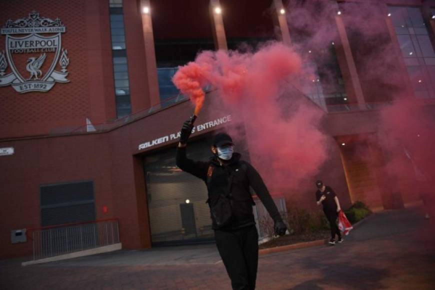 Las bengalas y cánticos no se hicieron esperar a las afueras de la casa del Liverpool, pese a que Gran Bretaña aún mantiene estrictas medidas de sanidad por la pandemia del coronavirus.