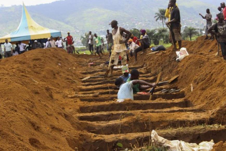 Hombres cavan fosas comunes para sepultar a víctimas mortales de inundaciones y deslizamientos de tierra en Waterloo, Sierra Leona.