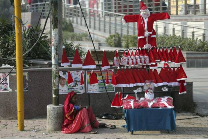 Una mujer vende trajes y gorros de Papá Noel en un puesto callejero en Amritsar, India.