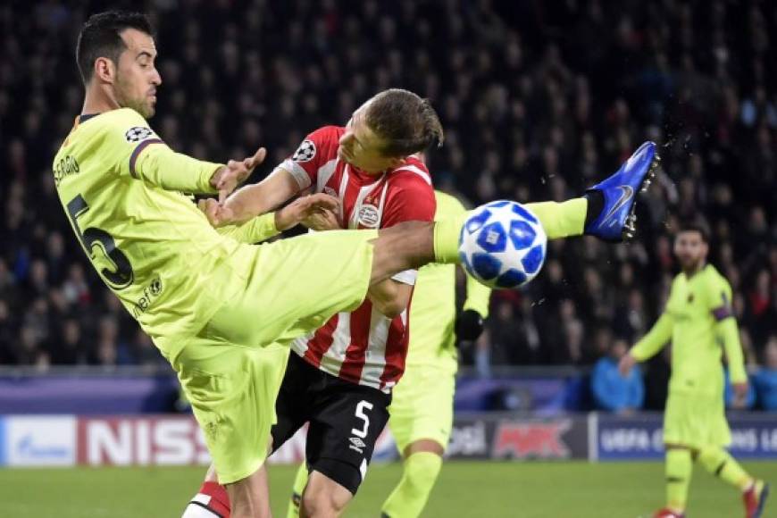 Sergio Busquets levanta mucho el pie para ganarle el balón a Daniel Schwaab del PSV.