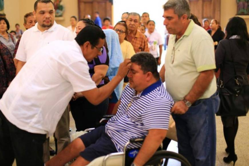 Un delegado de la palabra de Dios da la hostia a un hombre en silla de ruedas durante la misa del Miércoles de Ceniza en la iglesia San Pablo Apóstol de San Pedro Sula. Foto Jordan Perdomo