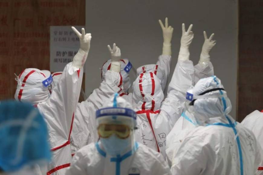 Medical staff cheer themselves up before going into an ICU ward for COVID-19 coronavirus patients at the Red Cross Hospital in Wuhan in China's central Hubei province on March 16, 2020. - China reported 12 more imported cases of the novel coronavirus on March 16 as the capital tightened quarantine measures for international arrivals to prevent a new wave of infections. (Photo by STR / AFP) / China OUT
