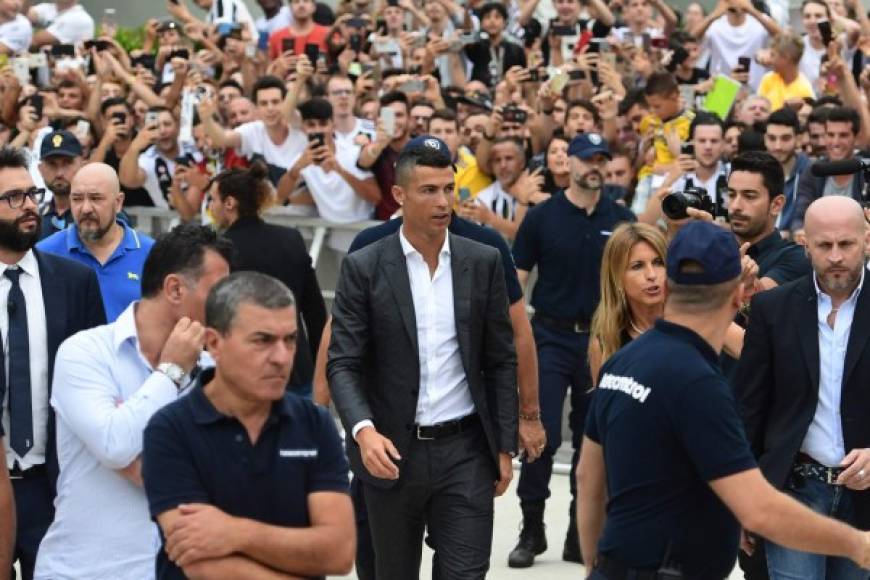 Durante casi un minuto, Cristiano Ronaldo, con camiseta blanca y traje gris, firmó autógrafos y estrechó manos, mientras los aficionados se agolpaban para ver de cerca al cinco veces Balón de Oro.<br/>