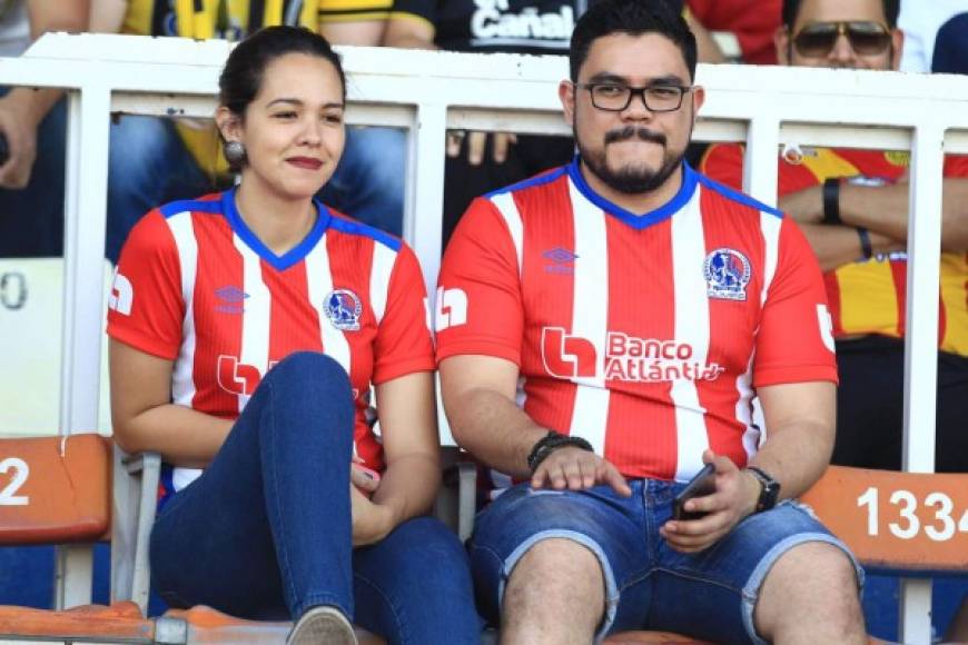 Una pareja de aficionados del Olimpia apoyando a su equipo en el clásico.