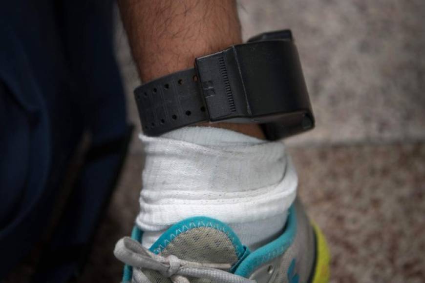 A Central American migrant wears an ankle monitor, issued in federal detention, after being released with fellow asylum seekers at a bus depot on June 11, 2019, in McAllen, Texas. (Photo by Loren ELLIOTT / AFP)