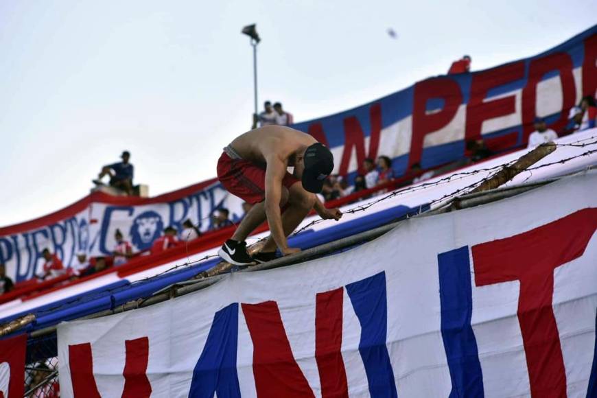 Este aficionado del Olimpia se ariesgó al subirse al alambrado del estadio Morazán para colocar una manta.