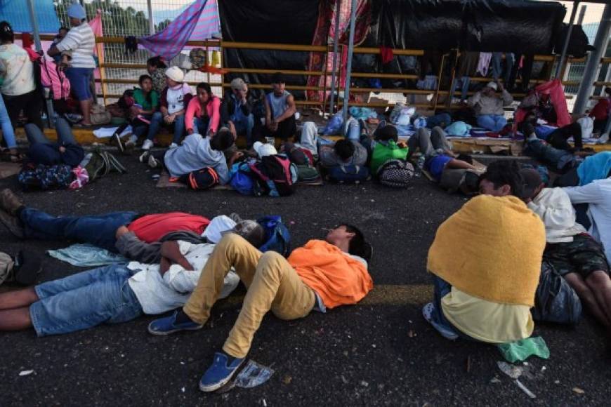 Honduran migrants heading to the United States with a second caravan rest at the border city of Ciudad Tecun Uman, Guatemala as they wait to cross to Mexico on January 19, 2019. - Hundreds of Central Americans entered Mexico illegally as the latest migrant caravan trying to reach the United States began crossing the Mexican-Guatemalan border en masse Friday (Photo by Johan ORDONEZ / AFP)