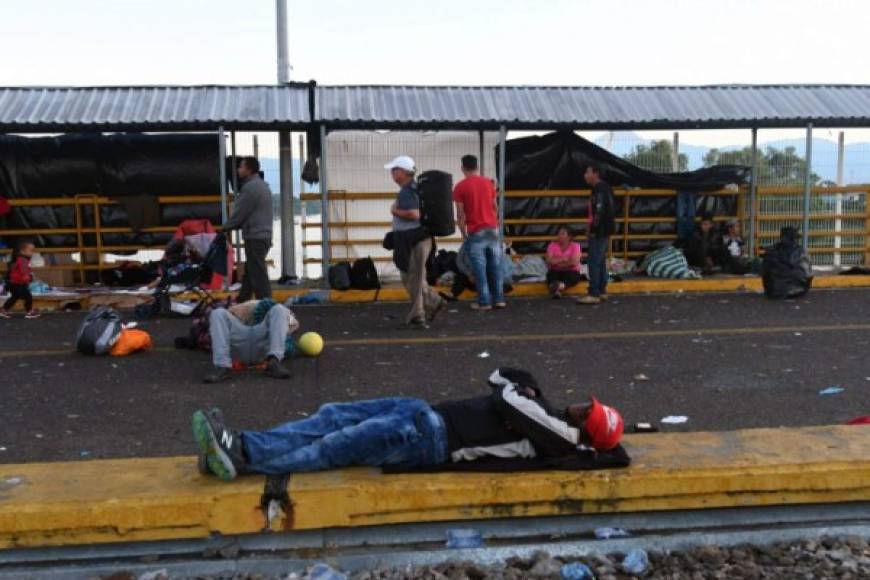 Las personas, entre ellas niños, siguen esperando para poder ingresar en territorio mexicano y así continuar su travesía.