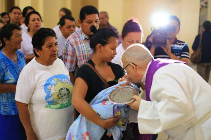 El sacerdote católico Saturnino Senis bendice a un bebé durante la misa del Miércoles de Ceniza. Foto Jordan Perdomo