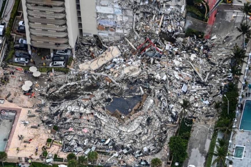 (FILES) In this file aerial view, shows search and rescue personnel working on site after the partial collapse of the Champlain Towers South in Surfside, north of Miami Beach, on June 24, 2021. - A memorial honoring the victims of an apartment building collapse nearly three weeks ago in the Florida beachfront community of Surfside may be built on the site of the disaster, officials said on July 13, 2021. The sudden condo collapse in a north Miami suburb killed at least 95 people, 85 of whom have been identified, said Miami-Dade County Mayor Daniella Levine Cava. Over a dozen are still missing. (Photo by CHANDAN KHANNA / AFP)