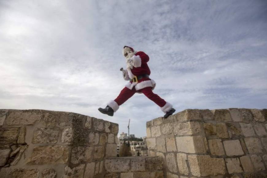 Un hombre disfrazado de Papá Noel camina por el muro de la Puerta de Jaffa, en Jerusalén, Israel.
