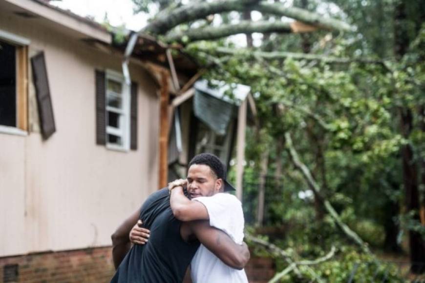 COLUMBIA, SC - OCTOBER 11: Hector Benthall, right, gets a hug from his neighbor Keito Jordan after remnants of Hurricane Michael sent a tree crashing into Benthall's home on October 11, 2018 in Columbia, South Carolina. Jordan was the first responder to the accident that sent at least one person to the hospital. Sean Rayford/Getty Images/AFP