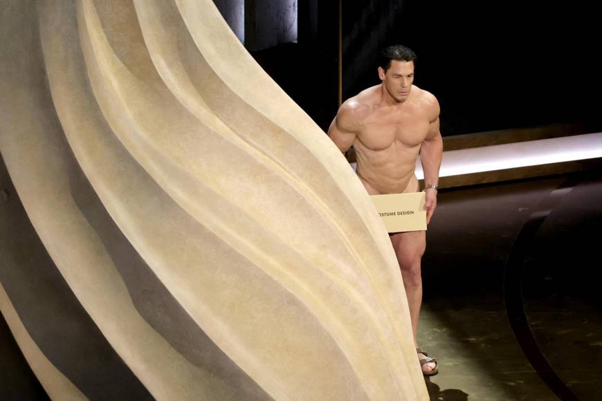 Finalmente, Cena salió detrás del escenario arrastrando los pies, con su virilidad cubierta por un pequeño sobre titulado Mejor Diseño de Vestuario, arrancando las carcajadas de todo el público presente.