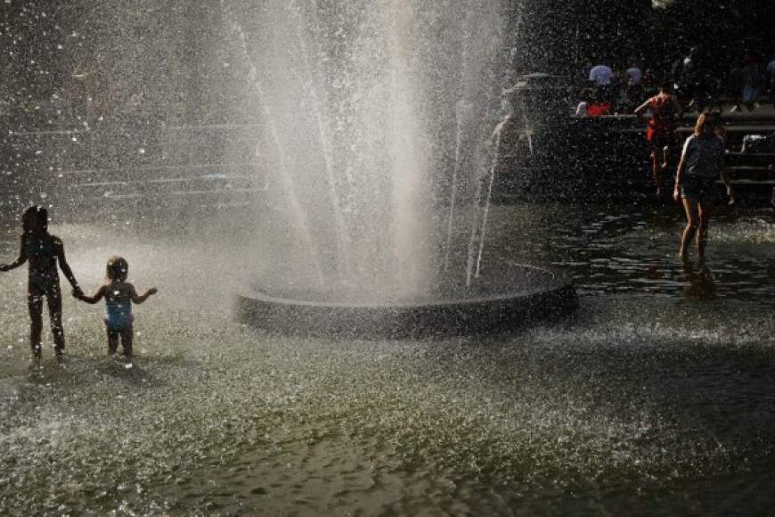 Los niños disfrutan de las actividades en las fuentes de agua en las plazas de Nueva York.