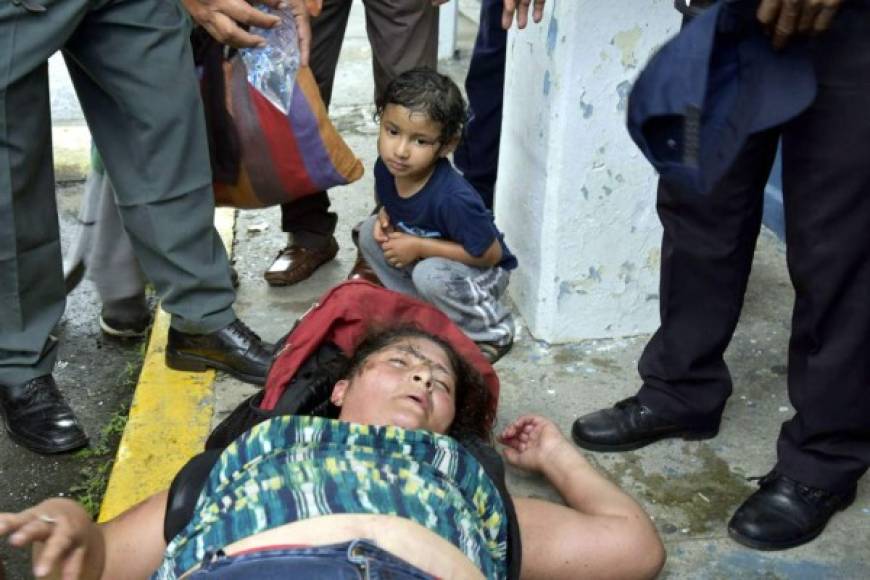 Una niña observa a una mujer inconsciente luego de que miles de migrantes hondureños logran librar el cero que une la frontera con Guatemala para ingresar. Foto EFE
