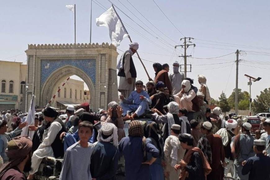 Taliban fighters stand on a vehicle along the roadside in Kandahar on August 13, 2021. (Photo by - / AFP)