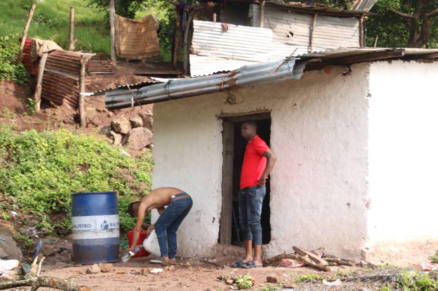 Migrantes varados piden agua en casas de la comunidad de El Higuito al quedar sin insumos, dinero y documentos. 