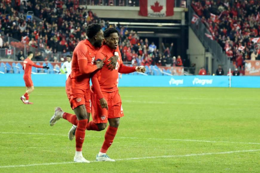 Alphonso Davies corriendo junto a Jonathan David para celebrar el tercer gol de Canadá.