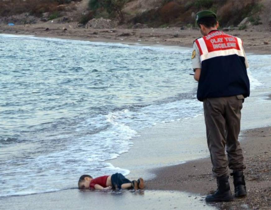 La crisis de refugiados que golpea a Europa estremeció al mundo con esta imagen que muestra a un agente de la policía turca al lado del cadáver de un niño en las costas en Bodrum, el sur de Turquía, el 2 de septiembre de 2015. <br/>El pequeño Aylan kurdi se ahogó después de que una embarcación que transportaba a los refugiados se hundiera mientras llegaban a la isla griega de Kos. El niño se convirtió en el símbolo de los refugiados. Foto: Nilufer Demir, AFP / Getty Images)