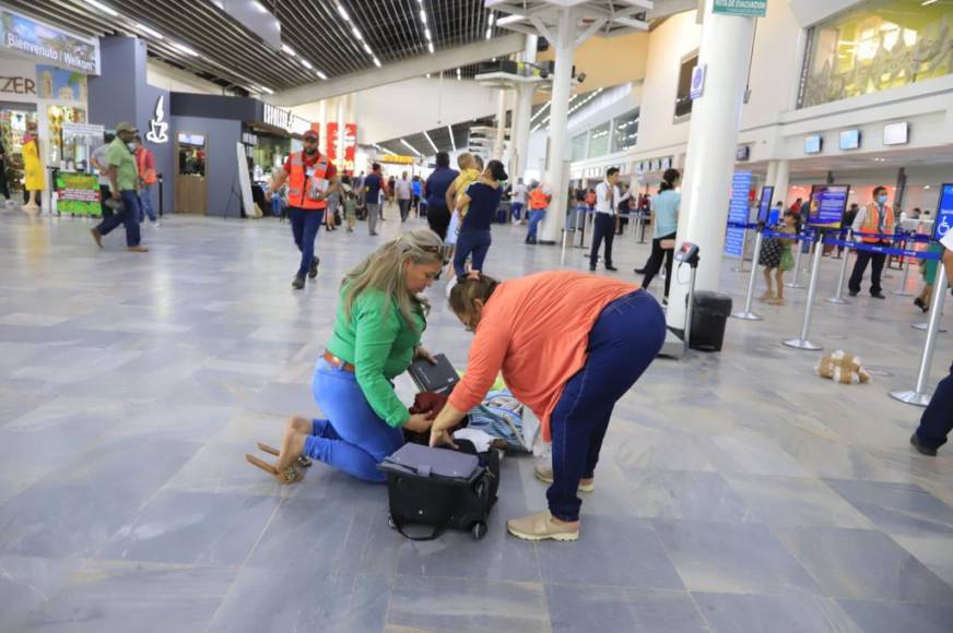 Personas de diferentes partes del país llegan al aeropuerto sampedrano y deben hacer cambios en sus maletas en el suelo porque no hay áreas modernas de descanso ni espera.