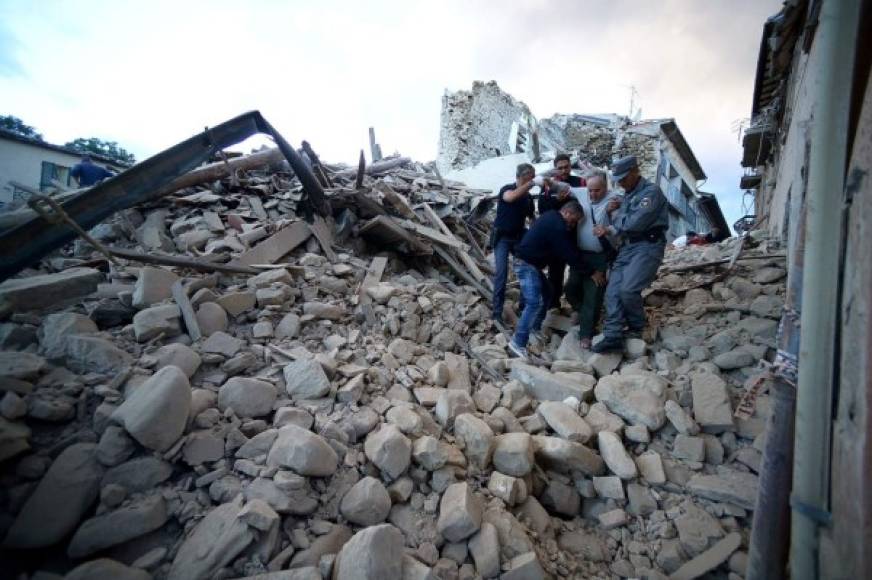 Rescatistas ayudan a un hombre sobreviviente al terremoto.