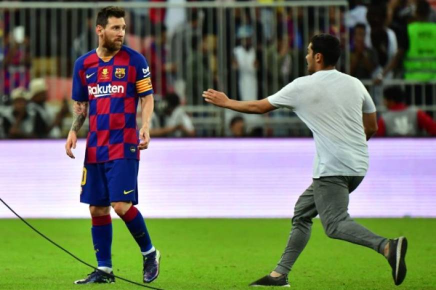 Un espontáneo saltó al campo para acercarse a Lionel Messi al final del partido. El argentino se vio sorprendido.