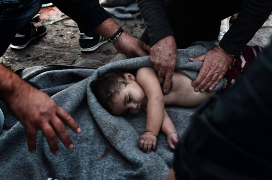 Paramédicos intentan reanimar a una bebé después de que la embarcación en la que viajaba junto a su familia naufragara en el mar Mediterráneo. Al menos siete personas, entre ellas cinco niños, murieron ahogados.