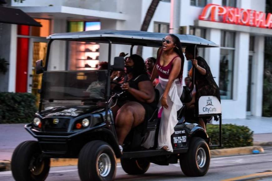 A group of women sing songs as they drive thru Miami Beach, Florida on June 26, 2020. - They are itching for a good time after months of lockdown, and may the coronavirus be damned: young adults in Florida are fueling a dangerous rise in COVID-19 infections. Feeling immortal, these fun-crazed people are finding ways to gather and party even though many bars and nightclubs remain closed as the Sunshine State reopened its economy this month. (Photo by CHANDAN KHANNA / AFP)