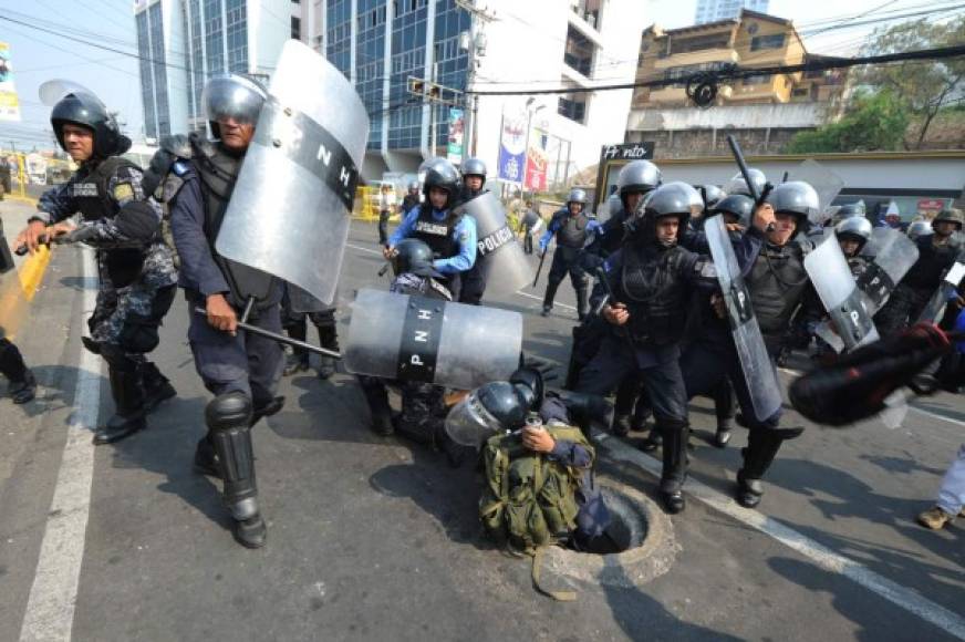 Indígenas lencas del Copinh se enfrentaron con policías antimotines frente a Casa Presidencial en Tegucigalpa. AFP