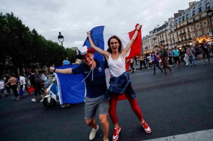 Esta pareja de franceses alzó con mucho orgullo su bandera en el centro de París.