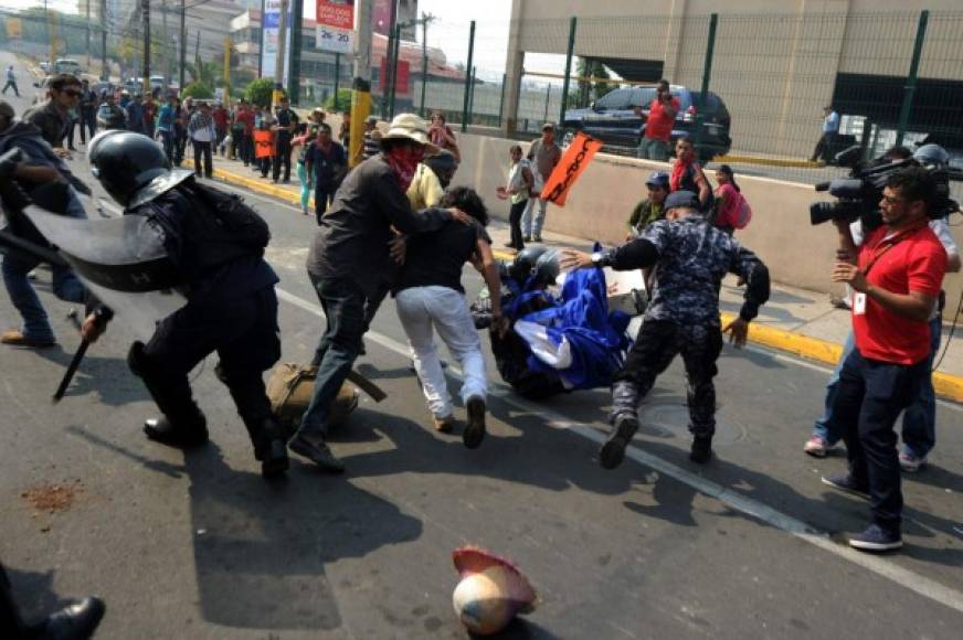 Indígenas lencas del Copinh se enfrentaron con policías antimotines frente a Casa Presidencial en Tegucigalpa. AFP