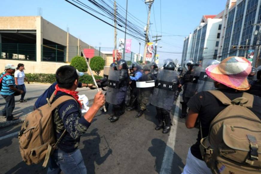 Indígenas lencas del Copinh se enfrentaron con policías antimotines frente a Casa Presidencial en Tegucigalpa. AFP