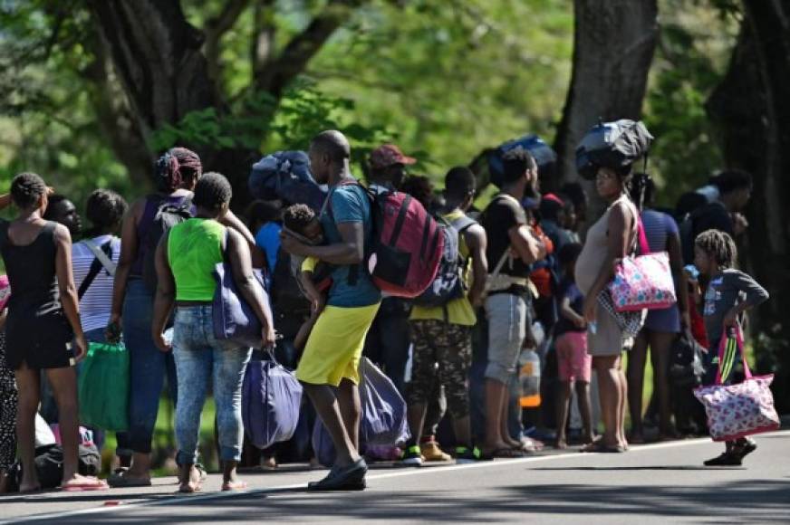Los migrantes africanos y haitianos permanecen al costado de una carretera después de pasar por un 'cruce ciego' de Nicaragua a Honduras en su camino a los Estados Unidos, en Guasaule, Honduras.