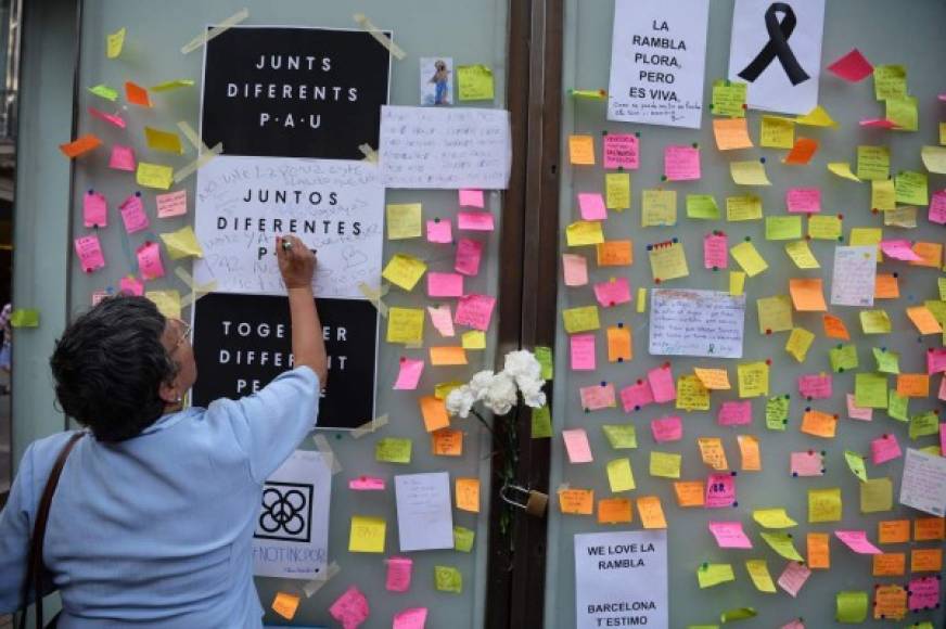 Una mujer escribe un mensaje en honor a las víctimas del ataque en Las Ramblas, Barcelona. AFP