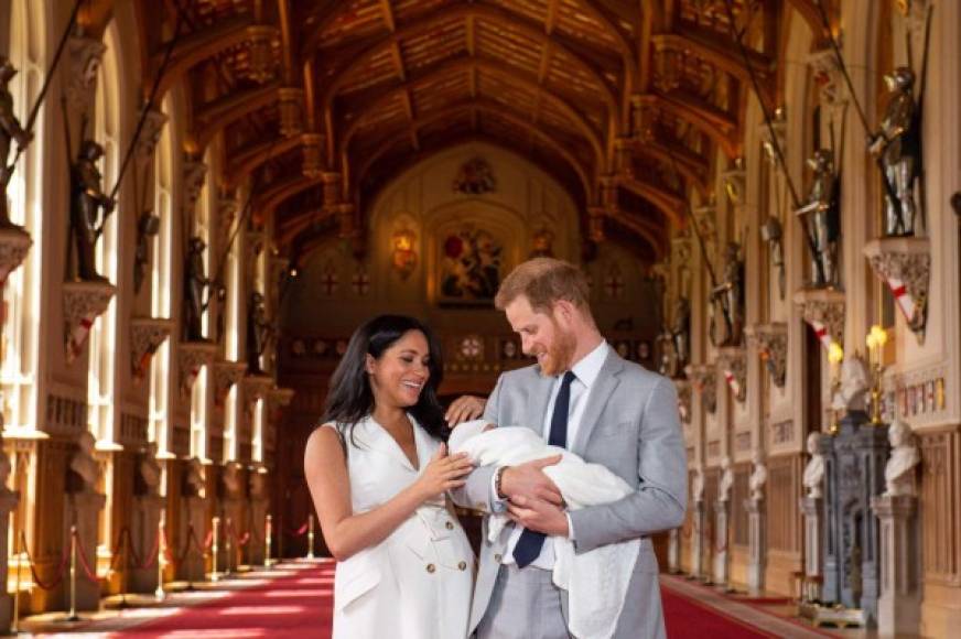 (FILES) In this file photo taken on May 08, 2019 Britain's Prince Harry, Duke of Sussex (R), and his wife Meghan, Duchess of Sussex, pose for a photo with their newborn baby son, Archie Harrison Mountbatten-Windsor, in St George's Hall at Windsor Castle in Windsor. - Scarred by the death of his mother, Prince Harry has struggled in the royal limelight for much of his life, and his fears for wife Meghan have now put him at loggerheads with his family. The younger son of the heir to the throne Prince Charles and the late Diana, princess of Wales, Harry, now 36, earned a reputation as a young playboy desperate to escape the royal straightjacket. Having left his wild-child ways behind him, the prince appeared to have found his place in the family with Meghan and son Archie. (Photo by Dominic Lipinski / POOL / AFP)