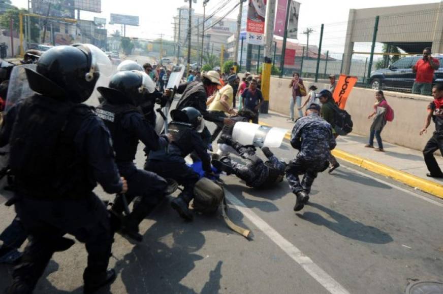 Indígenas lencas del Copinh se enfrentaron con policías antimotines frente a Casa Presidencial en Tegucigalpa. AFP