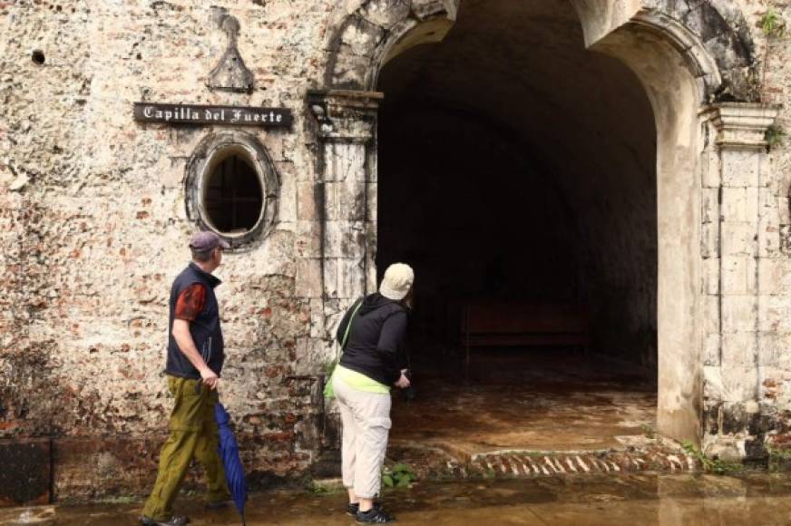 Dos turistas se asoman a una de las capillas del castillo de San Fernando.