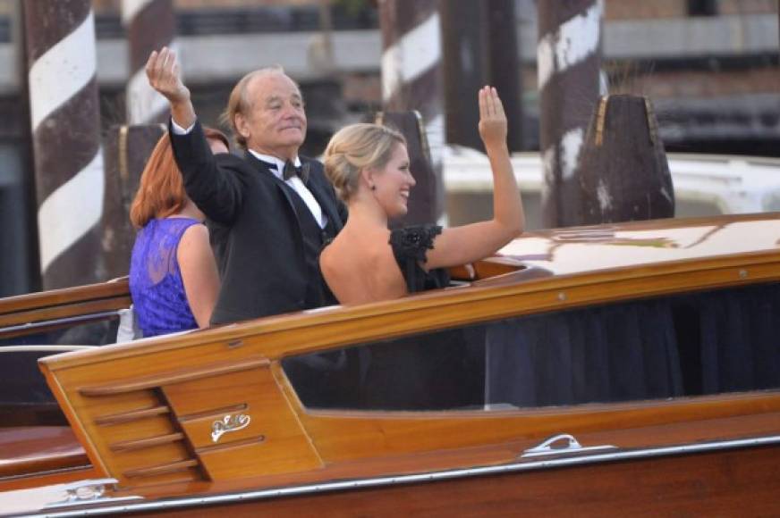 El actor Bill Murray saluda junto a una de sus acompañantes a bordo de un barco taxi.